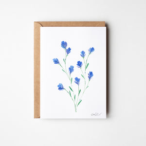 Eco-friendly watercolour print of loosely painted tiny blue wildflowers, scattered with a light, whimsical touch.