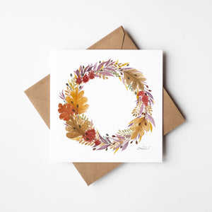 Watercolour greeting card featuring a beautiful autumn wreath with rich oranges, deep reds, and earthy greens. The design evokes the cozy charm and beauty of the fall season, bringing warmth and elegance to any space.