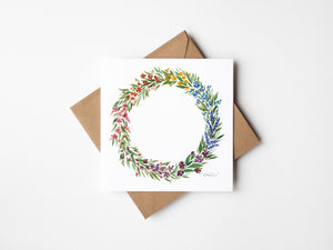 Watercolour print greeting card featuring a spring wreath design with bright colors, fresh green leaves, and vibrant flowers. The card captures the renewal and warmth of the spring season, evoking a sense of nature’s beauty and joy.