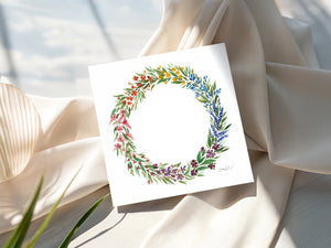 Watercolour print greeting card featuring a spring wreath design with bright colors, fresh green leaves, and vibrant flowers. The card captures the renewal and warmth of the spring season, evoking a sense of nature’s beauty and joy.
