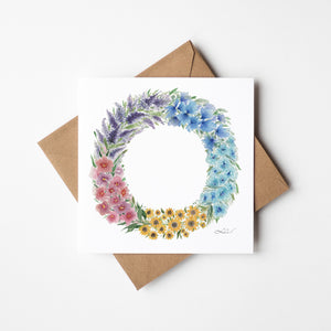Watercolour illustration of floral blooms that make up a summer wreath on a greeting card.