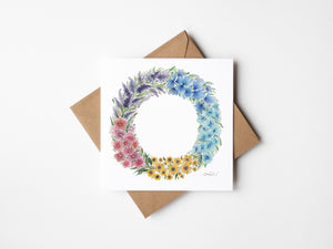 Watercolour illustration of floral blooms that make up a summer wreath on a greeting card.