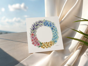 Watercolour illustration of floral blooms that make up a summer wreath on a greeting card.