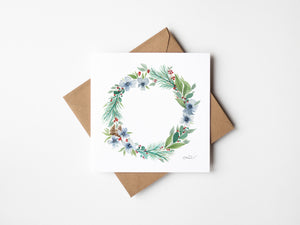 Watercolour illustration of a winter wreath made of cool blues, frosty whites, and soft greens capturing the serene essence of winter, creating a peaceful atmosphere.