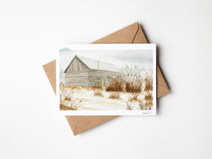 Watercolour greeting card featuring an old barn in the fog, surrounded by tall grass. The soft, misty atmosphere evokes a sense of peaceful solitude and rustic charm.