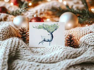 Christmas Reindeer Greeting Card – Eco-friendly greeting card featuring a hand-painted watercolour illustration of a reindeer in a wintry landscape, capturing the festive spirit.