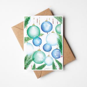 Festive Ornaments Greeting Card – Eco-friendly greeting card featuring a delicate watercolour illustration of ornamental balls hanging from a Christmas tree, capturing the magic of the holiday season.