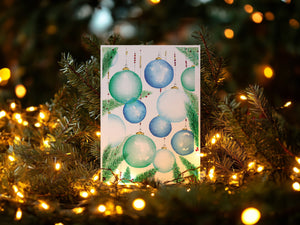 Festive Ornaments Greeting Card – Eco-friendly greeting card featuring a delicate watercolour illustration of ornamental balls hanging from a Christmas tree, capturing the magic of the holiday season.