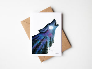 Watercolour greeting card featuring a silhouette of a wolf howling at a full moon, set against a backdrop of a vibrant aurora and a starry sky. The design captures the mystical and untamed beauty of the night.