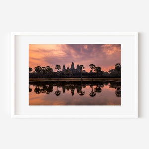 Fine art landscape photograph of Angkor Wat at dawn, with a soft veil of colour, tranquil reflection, and atmospheric light surrounding the temple silhouette.