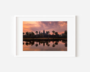 Fine art landscape photograph of Angkor Wat at dawn, with a soft veil of colour, tranquil reflection, and atmospheric light surrounding the temple silhouette.