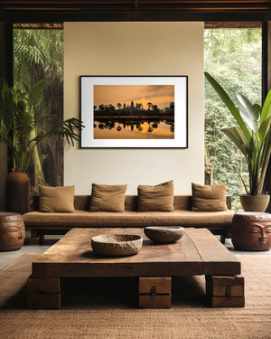 Fine art landscape photograph of Angkor Wat at sunrise, with golden light, sun mirrored in still water, and a serene, atmospheric temple silhouette.