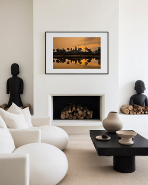 Fine art landscape photograph of Angkor Wat at sunrise, with golden light, sun mirrored in still water, and a serene, atmospheric temple silhouette.
