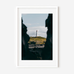 Fine art photography print featuring a lone lighthouse against Iceland's rugged coastal scenery.
