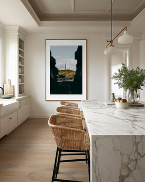 Fine art photography print featuring a lone lighthouse against Iceland's rugged coastal scenery.