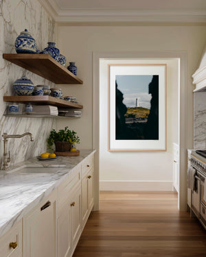 Fine art photography print featuring a lone lighthouse against Iceland's rugged coastal scenery.