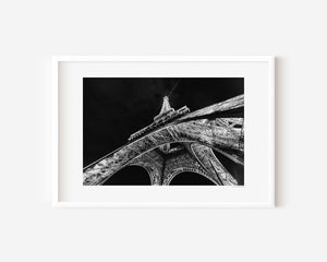 Fine art photograph of the Eiffel Tower at night, glowing against the Parisian sky in a romantic, luminous scene.
