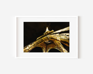 Fine art photograph of the Eiffel Tower at night, glowing against the Parisian sky in a romantic, luminous scene.