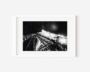 Fine art photograph of the Eiffel Tower at night, showing sparkling, bursting lights against the Parisian sky.