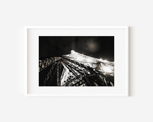 Fine art photograph of the Eiffel Tower at night, showing sparkling, bursting lights against the Parisian sky.