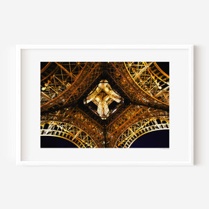 Fine art photograph of the Eiffel Tower at night, highlighting the star-shaped pattern of lights beneath its structure.