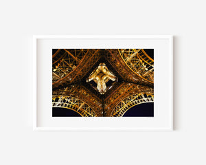 Fine art photograph of the Eiffel Tower at night, highlighting the star-shaped pattern of lights beneath its structure.