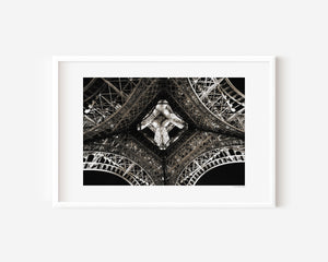 Fine art photograph of the Eiffel Tower at night, highlighting the star-shaped pattern of lights beneath its structure.