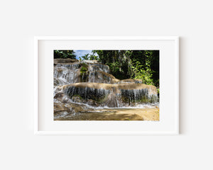 Fine art photograph of water cascading over rocks in a jungle setting, emphasizing motion, texture, and contrast.