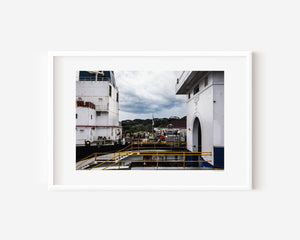 View from the top of the original Gatun locks, showing another ship passing through the adjacent chamber with the Panama flag visible in the background.