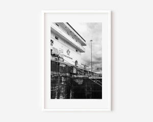 Angled view of the Panama Canal locks showing the Canal de Panamá sign and a locomotive moving the lock doors in a fine art photograph.