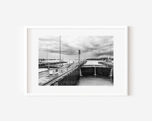 Forward-facing view inside the Panama Canal locks showing tall closed lock doors and the canal extending ahead in a fine art photograph.