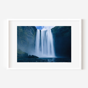 Fine art photograph of Skogafoss waterfall in Iceland, capturing its powerful vertical drop and mist in dramatic natural light.