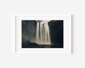 Fine art photograph of Skogafoss waterfall in Iceland, capturing its powerful vertical drop and mist in dramatic natural light.