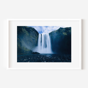 Fine art photograph of Skogafoss waterfall in Iceland, showing its vast surrounding landscape and mist-filled atmosphere.