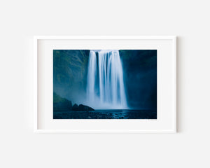 Fine art photograph of Skogafoss waterfall in Iceland, capturing its powerful vertical drop and mist in dramatic natural light.